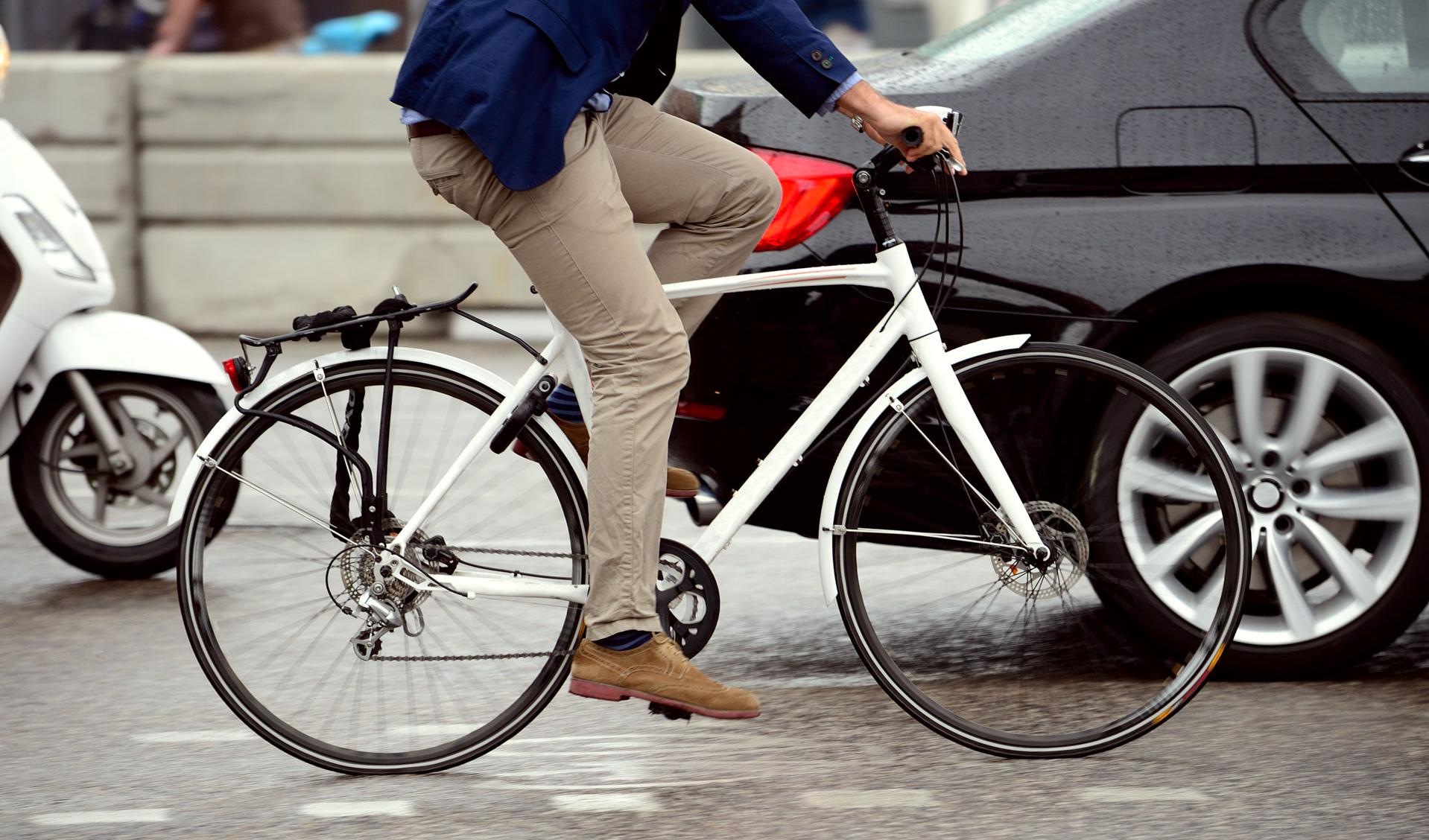 Sicher unterwegs mit Fahrrad und Pedelec im Herbst und Winter Mann auf Fahrrad auf einer dicht befahrenen Straße